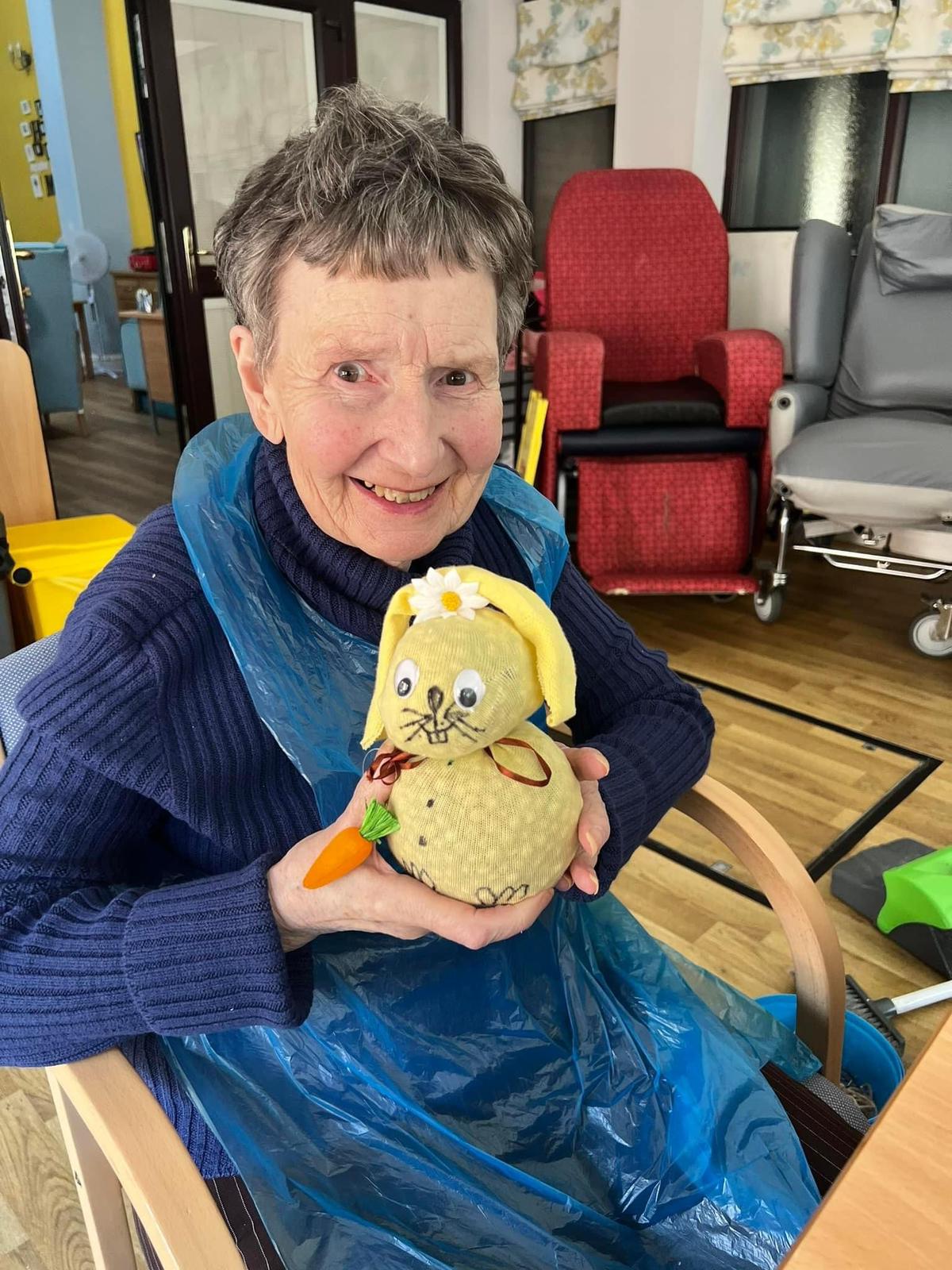 Resident holding a decorated pumpkin in a common area