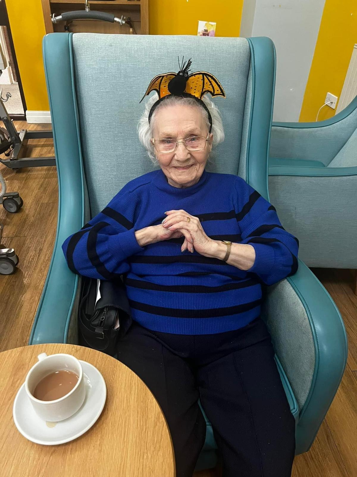 Senior woman in a common area with a playful headband.
