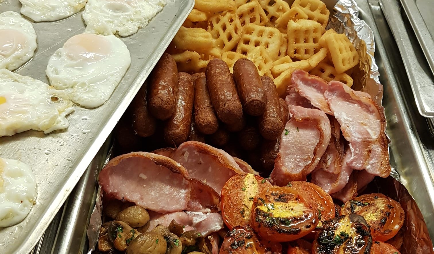 Assorted breakfast items including eggs, sausages, and bacon.