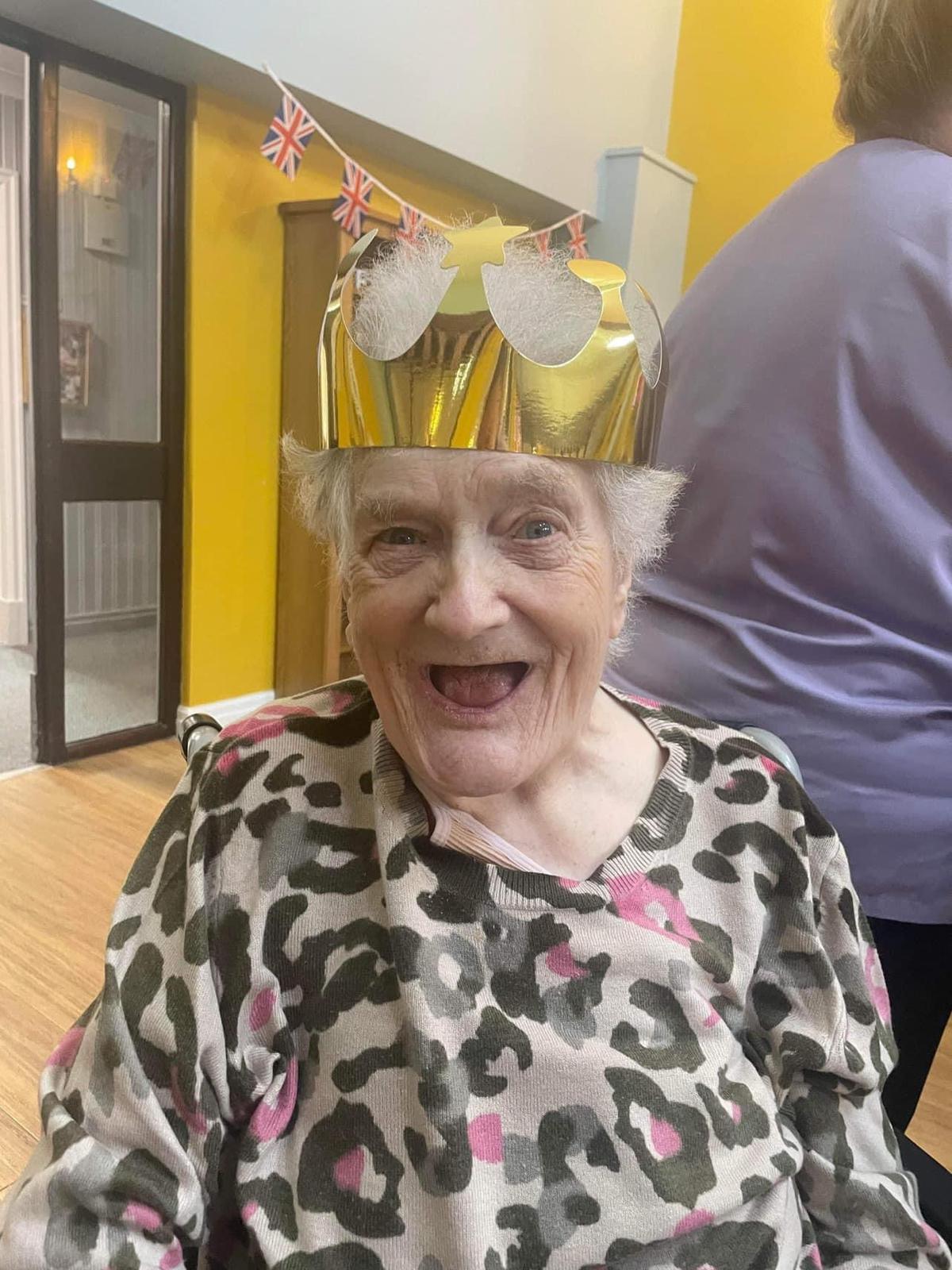 Elderly woman celebrating with a festive crown.