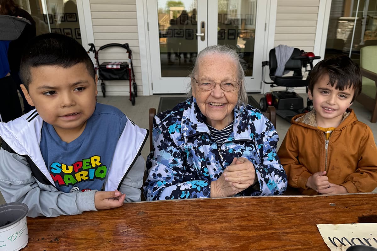 Two children and an elderly woman enjoying a moment together