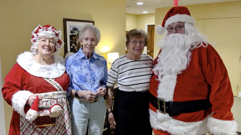 Residents and staff celebrating with Santa in a common area