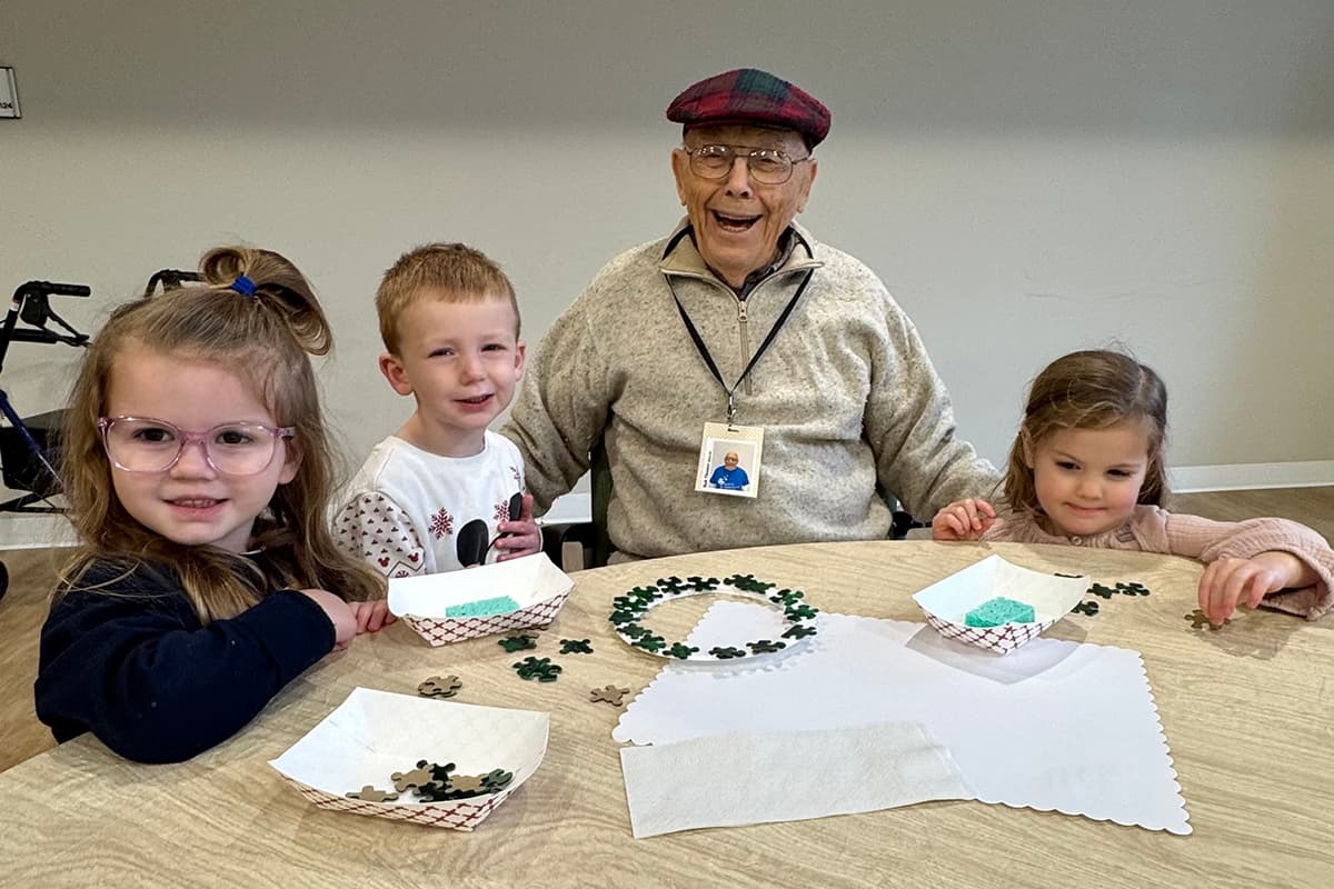 An elderly man enjoying craft time with children
