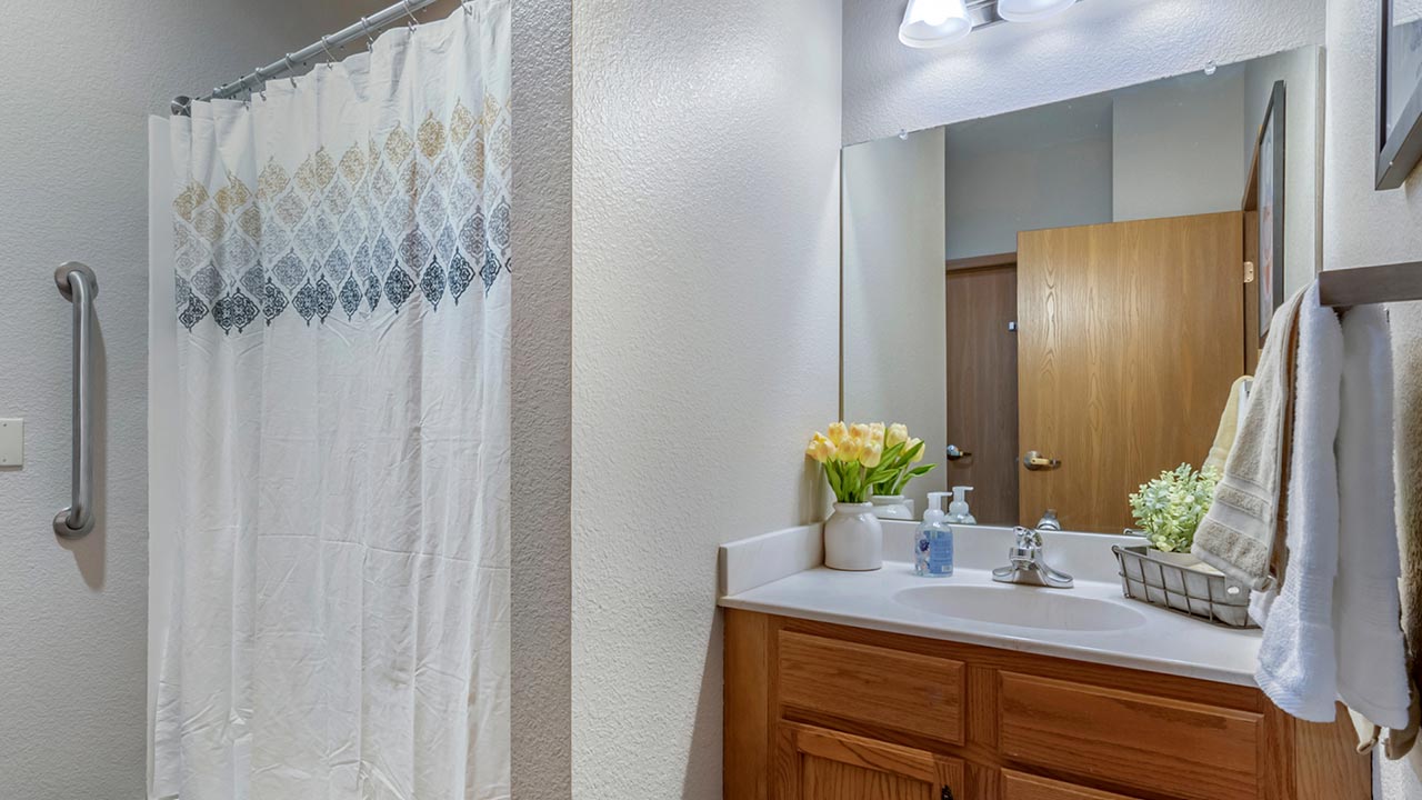 Well-lit bathroom with flowers and toiletries