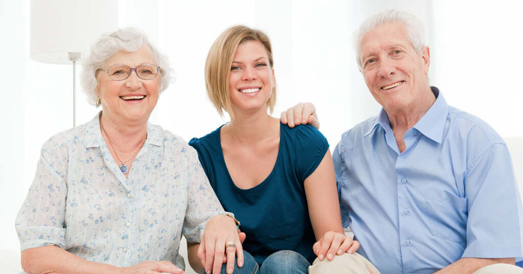 Residents smiling with a caregiver in a bright room