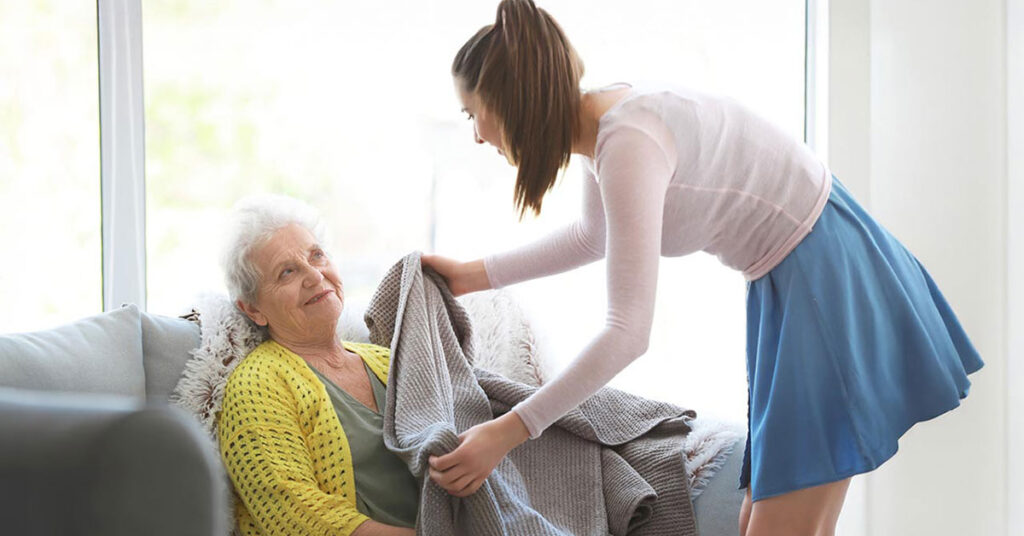A caregiver assisting a senior woman indoors