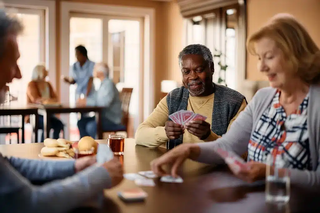 Residents playing cards in a bright common area
