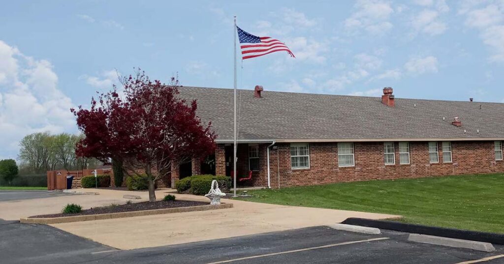 Front exterior view of the facility with flag and landscaping