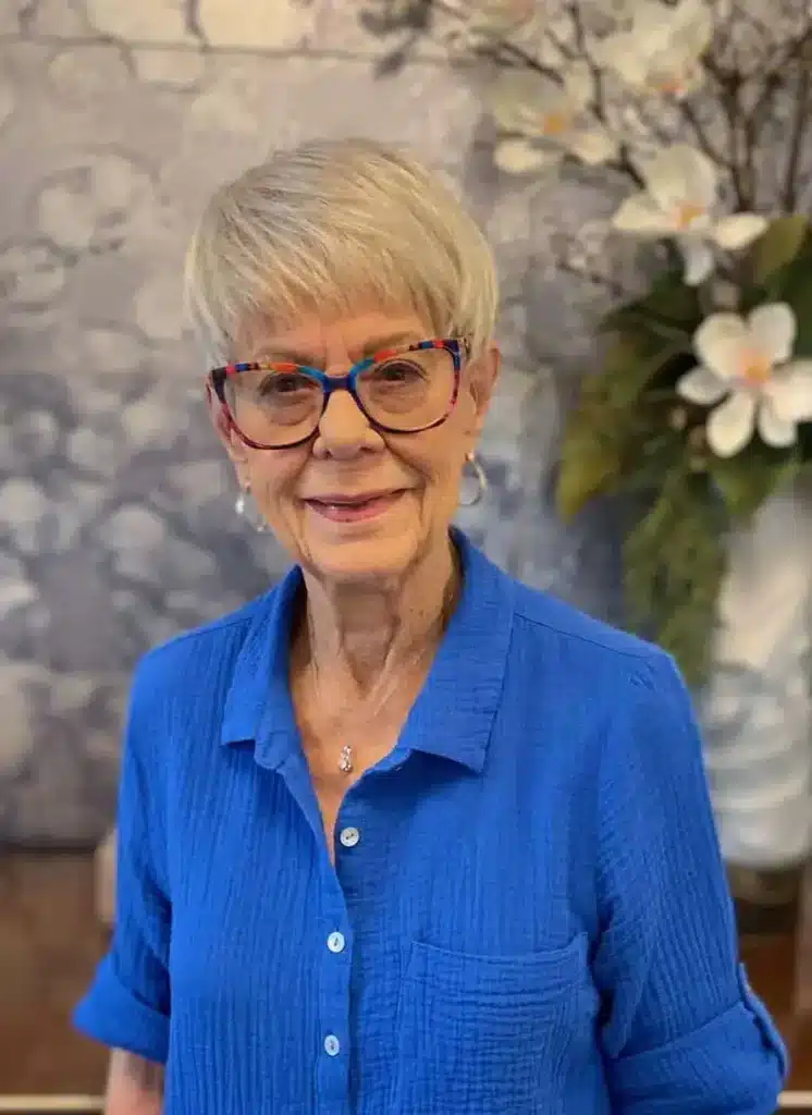 Smiling resident in a blue shirt with floral background
