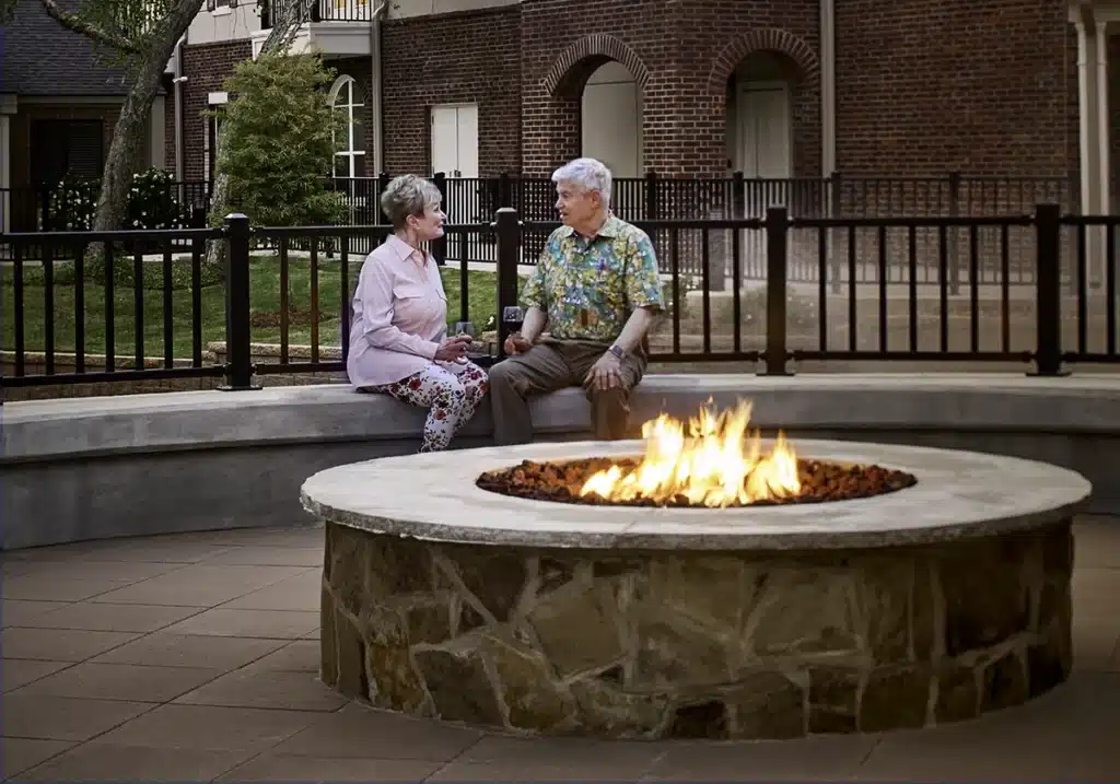 Two residents enjoying a conversation by a fire pit