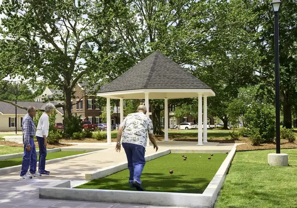 Residents playing bocce ball in a landscaped outdoor area