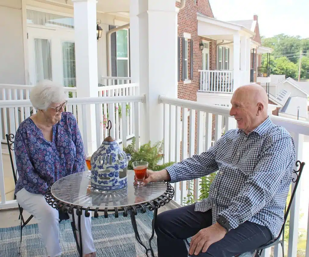 Two residents enjoying drinks on a balcony