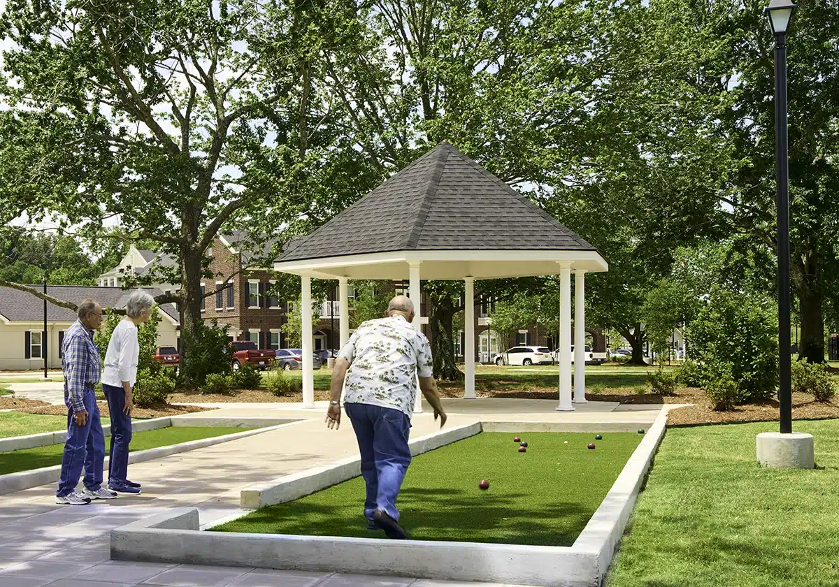 Residents playing bocce ball in a garden area
