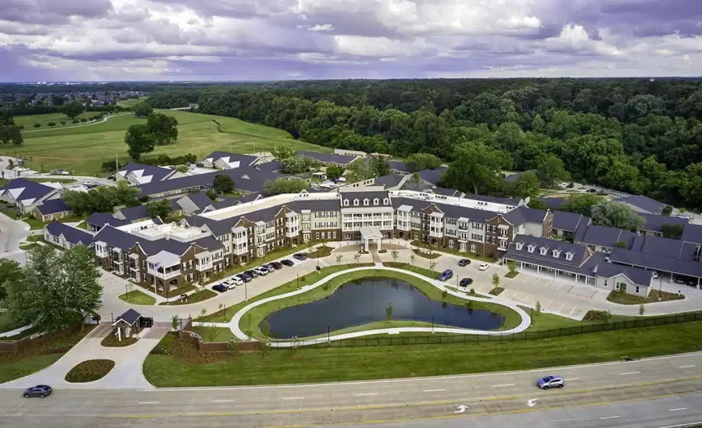 Aerial view of a senior living campus with a pond