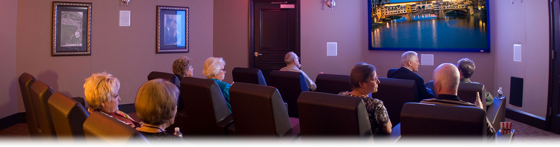 Residents watching a film in a cozy theater setting