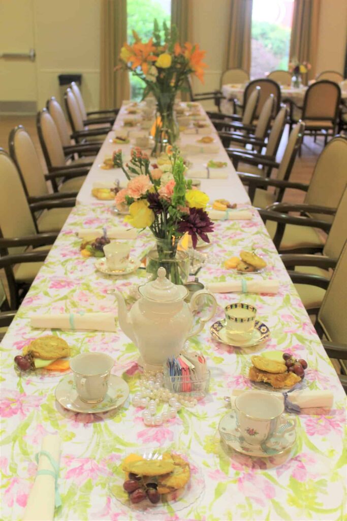 Elegantly set dining table with tea pots and flowers
