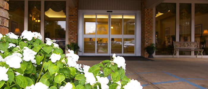 Entrance of a senior living facility with flowers