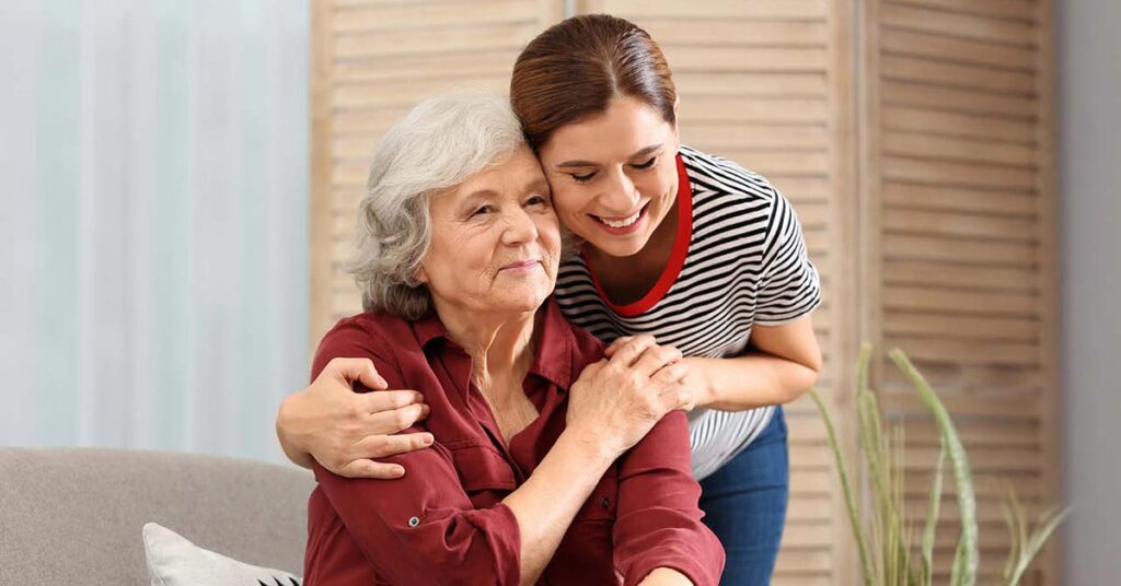 A caregiver and resident sharing a warm moment in a cozy interior