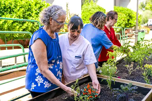 Residents gardening with staff in an outdoor space
