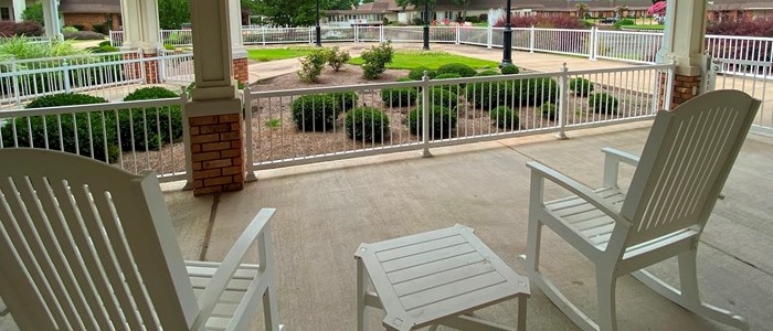 Patio area with rocking chairs and landscaped garden
