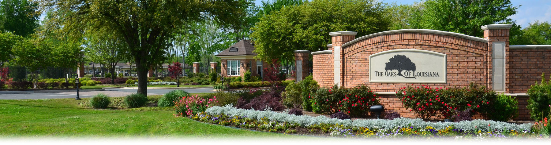 Welcoming entrance with landscaped gardens at The Oaks of Louisiana