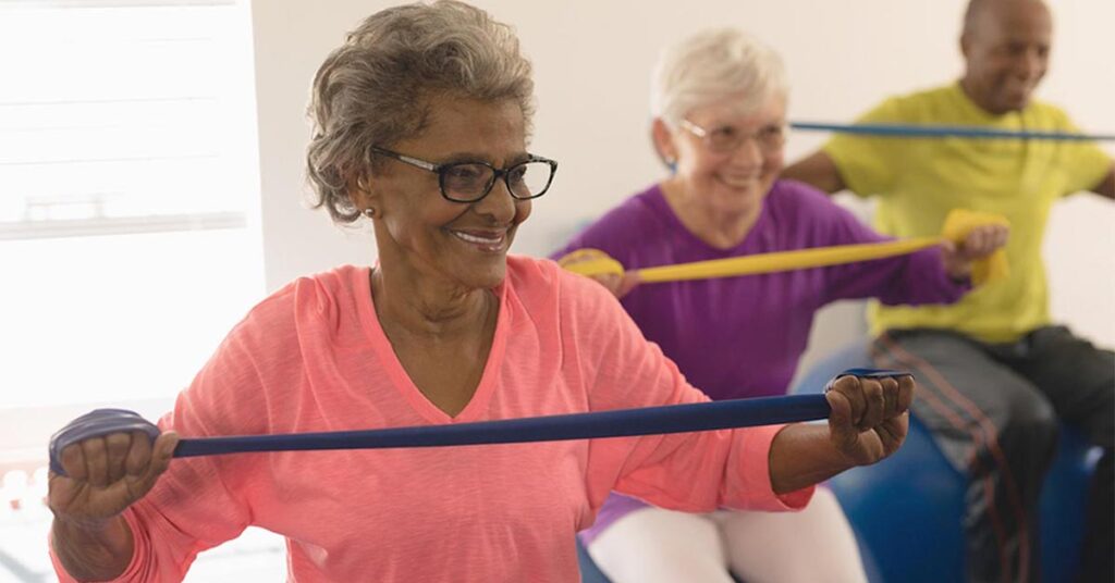 Residents participating in a group exercise class with resistance bands