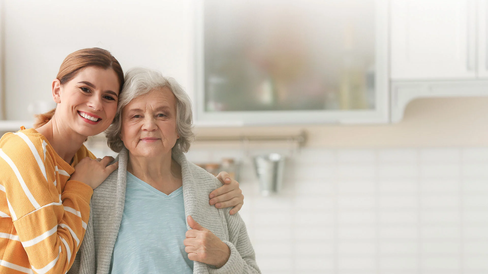 A caregiver with a resident in a bright kitchen