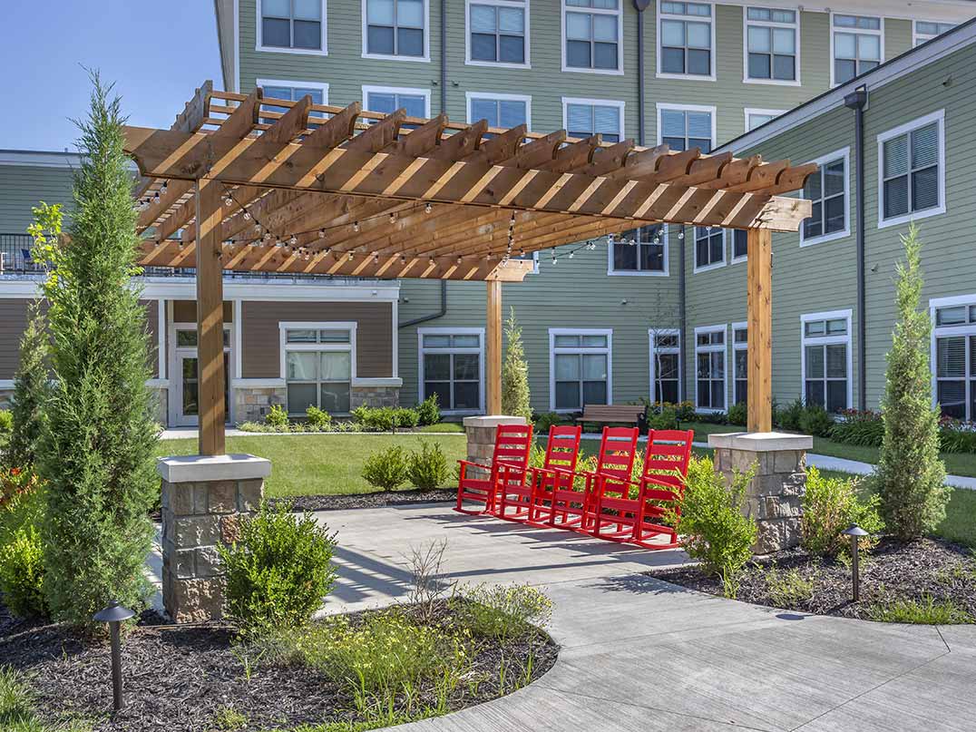 Outdoor space with a pergola and red rocking chairs