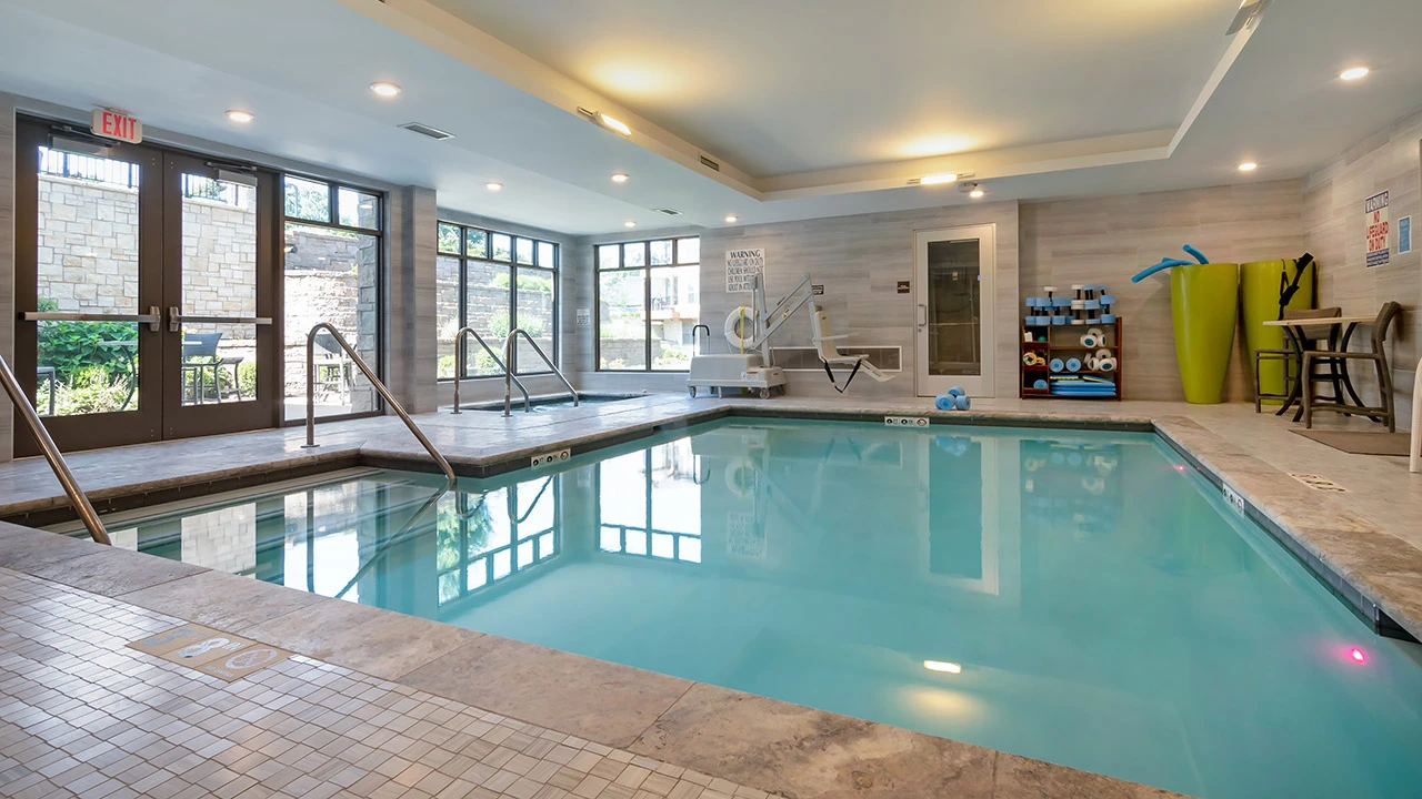 Indoor swimming pool area with sunlit windows