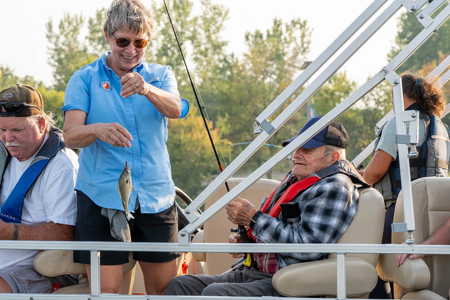 Seniors fishing with staff on a boat
