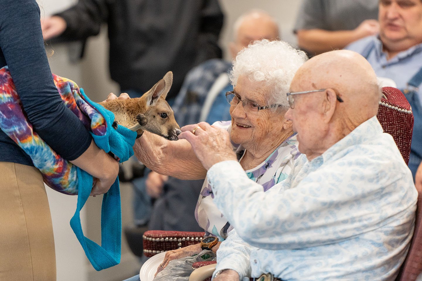 Residents interacting with a small animal during an activity.