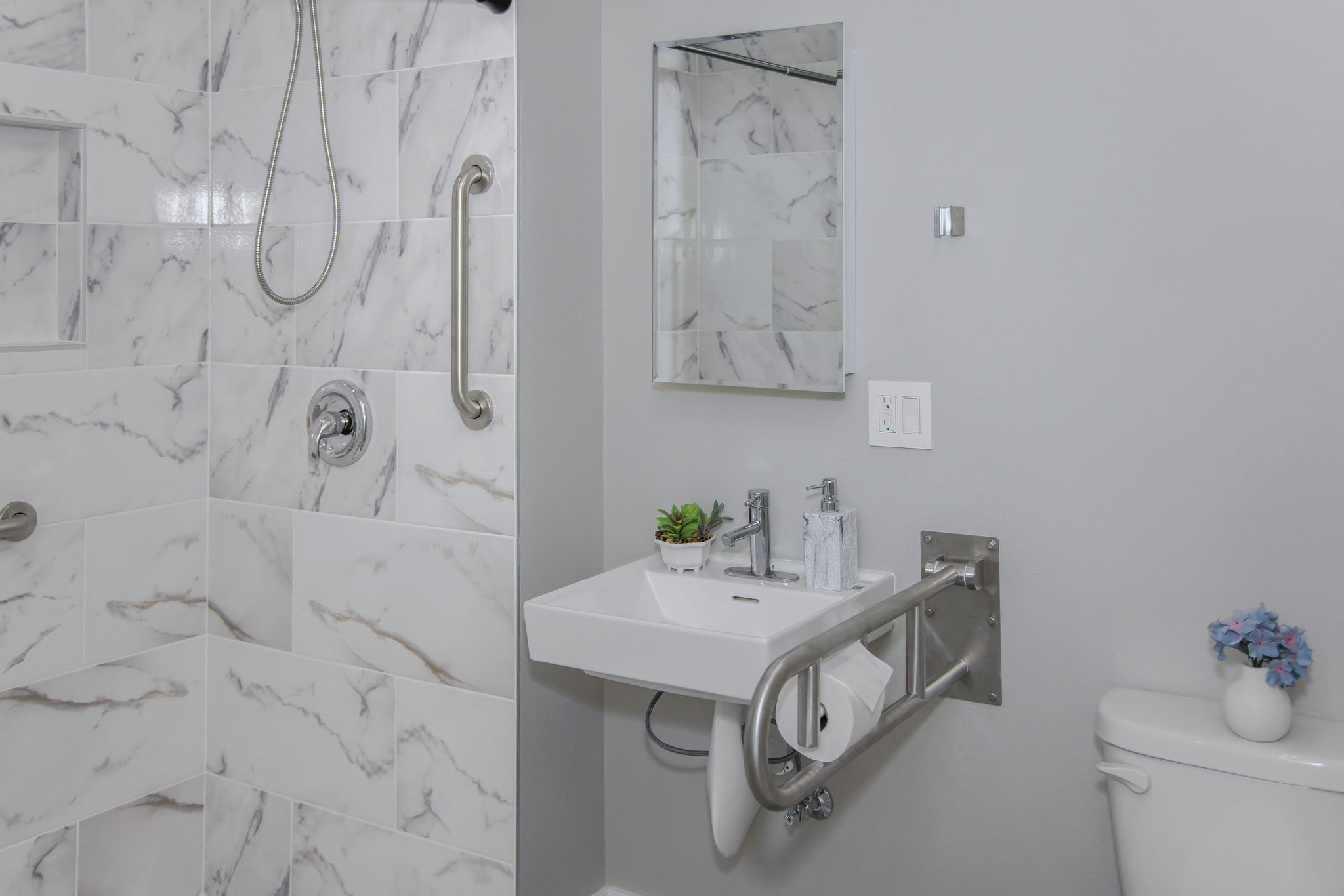 Stylish bathroom with grab bars and modern fixtures