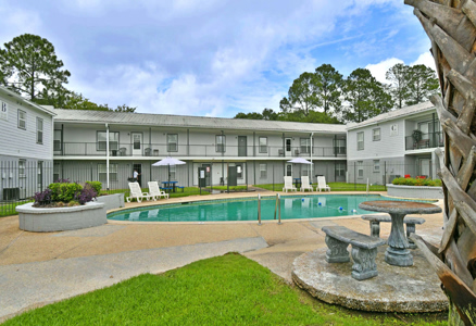 Outdoor pool area with lounge chairs and landscaping.