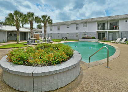 Outdoor pool area with landscaping and seating