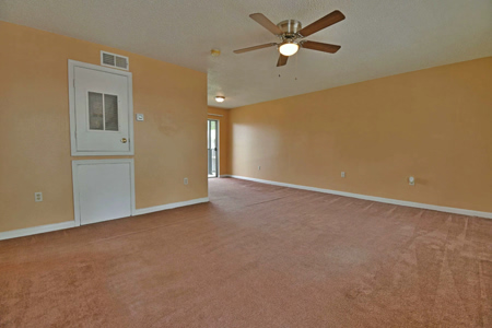 Empty living room with a ceiling fan