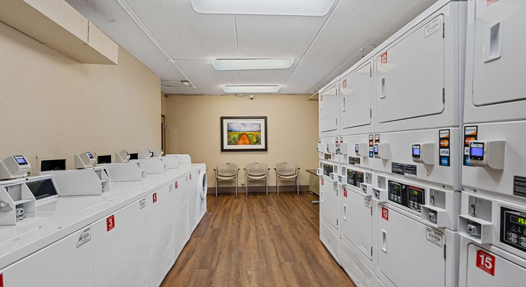 Laundry room with machines and seating area