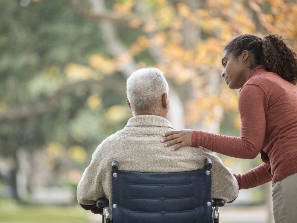 Caregiver with a resident outdoors in a wheelchair