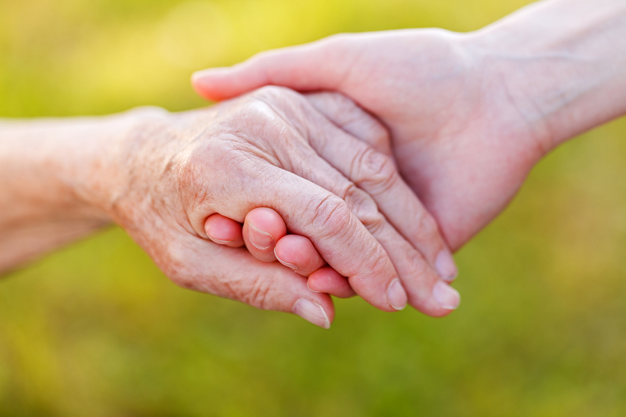 Two hands holding each other, symbolizing care