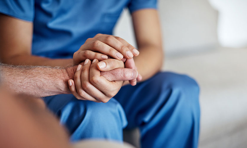 Caregiver holding hands with a resident