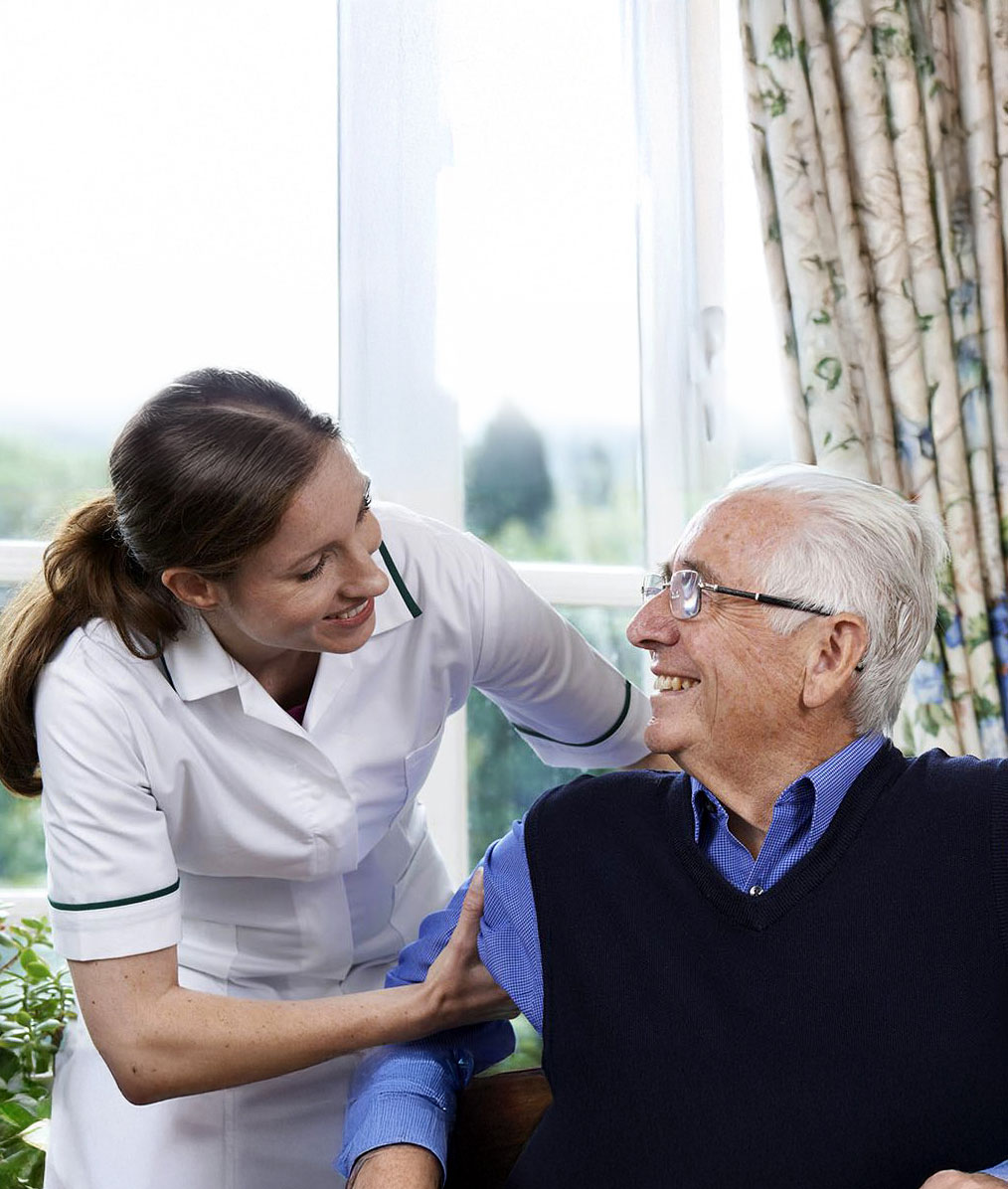 Nurse assisting a senior resident with a smile.