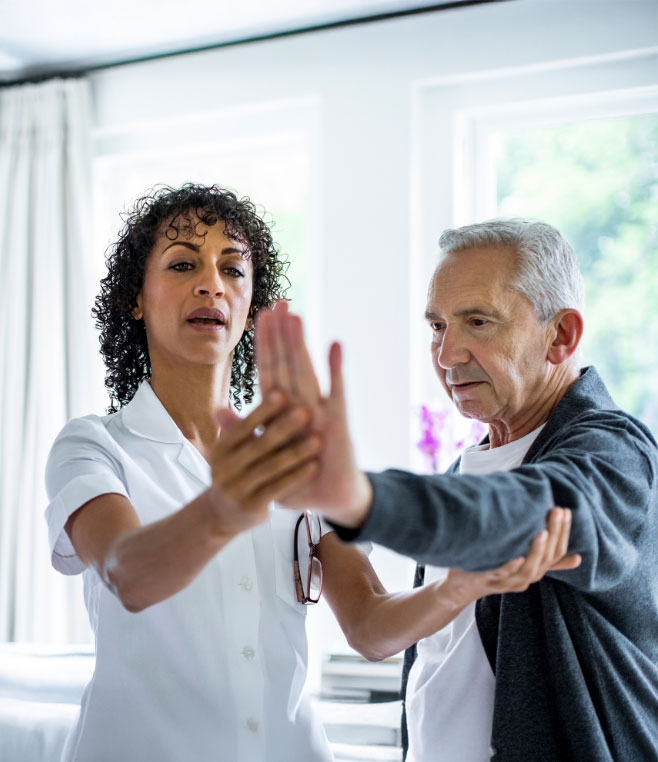 Staff assisting a resident in a therapy exercise.