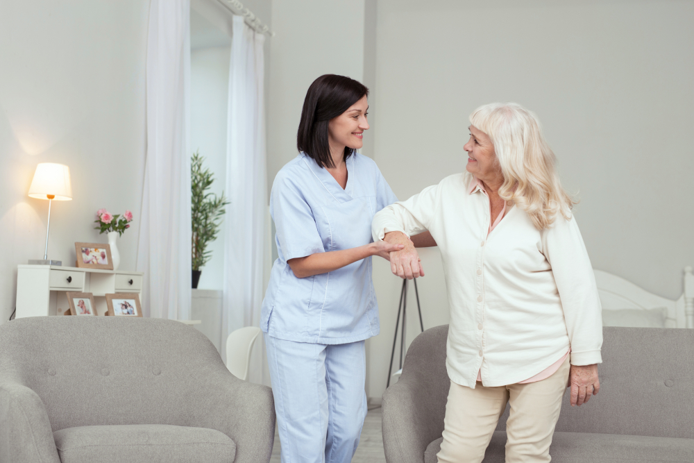 Caregiver assisting a senior resident in a bright room