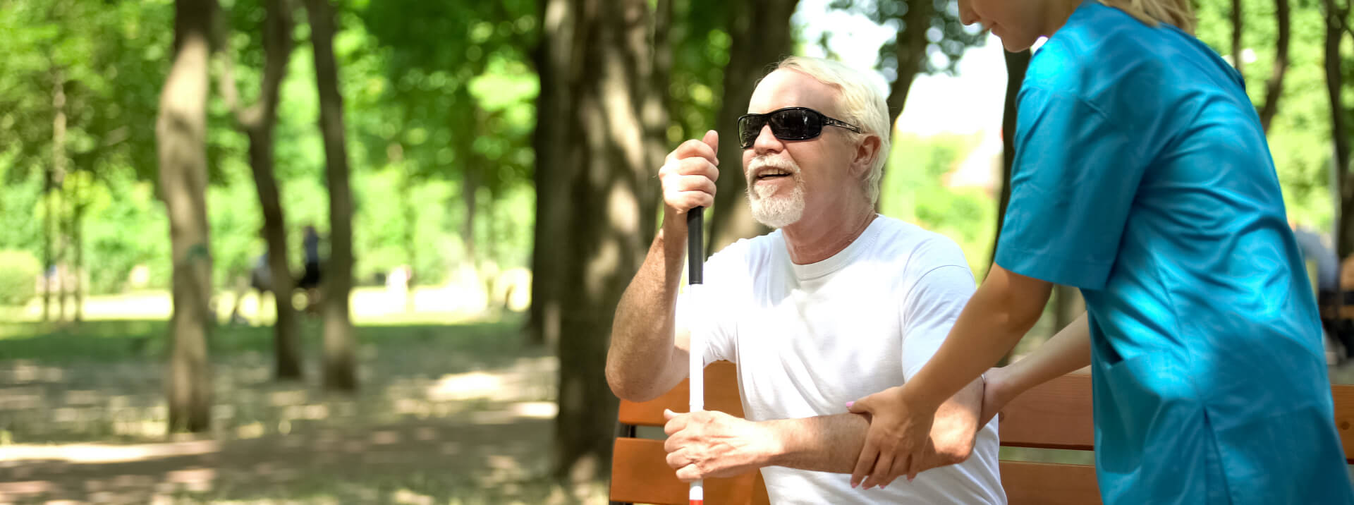 Senior man interacting with a caregiver in a park