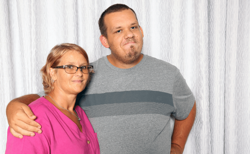 Two people posing together, smiling.