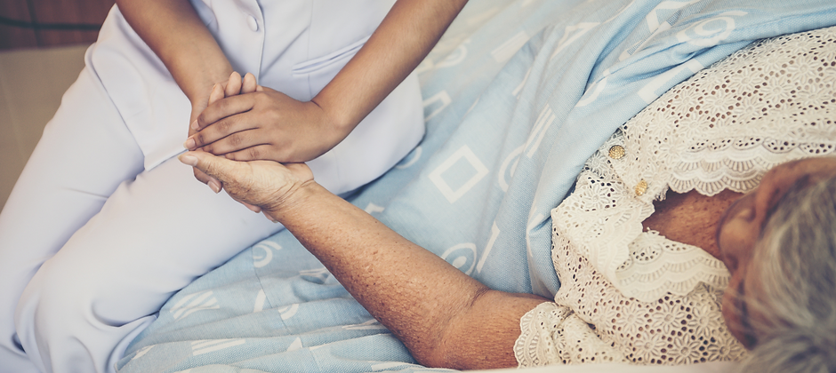 Caregiver holding the hand of a senior resident