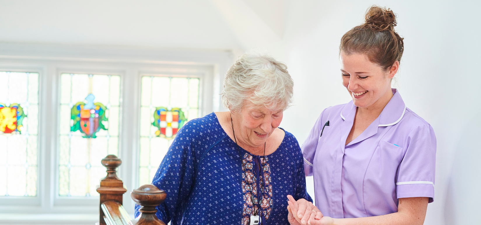 Nurse assisting an elderly resident on stairs.