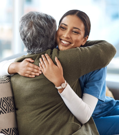 Caregiver and resident sharing a warm embrace.