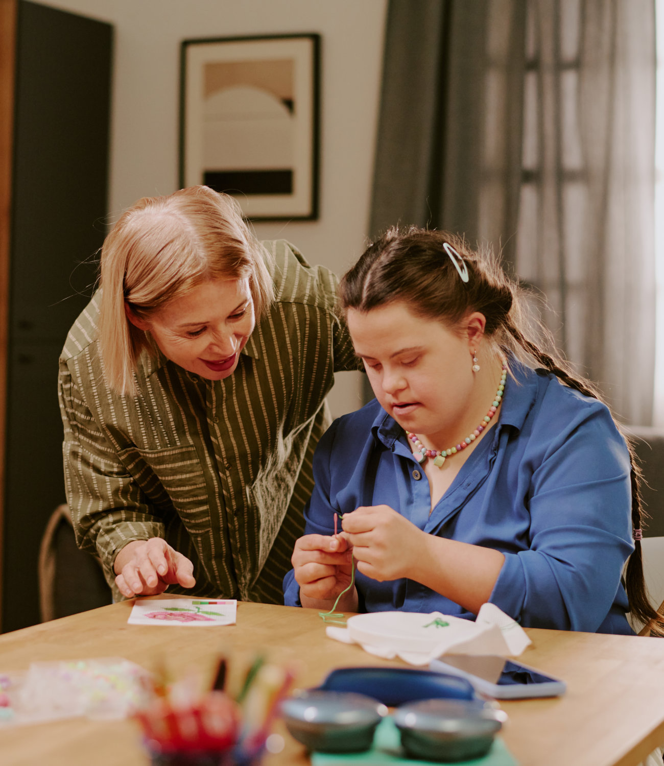A caregiver assisting a resident in an arts activity.