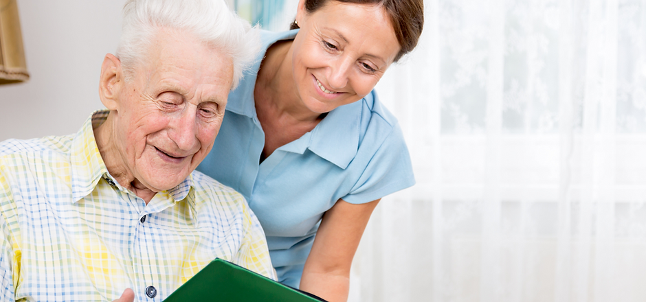 Senior man smiling with caregiver in a shared space.