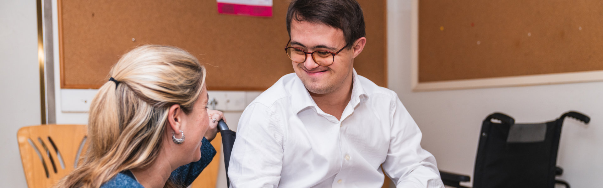 Two individuals engaged in conversation indoors.